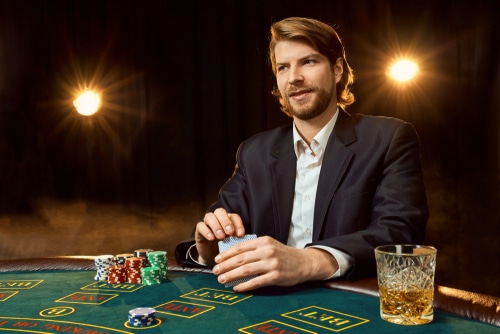 homme en costume assis à une table de jeu