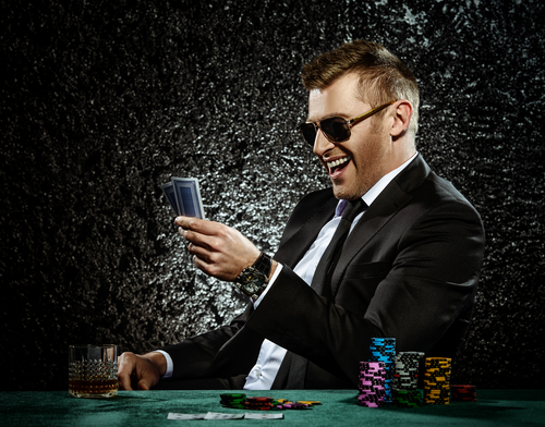 homme buvant et jouant dans un casino avec une grande quantité de jetons