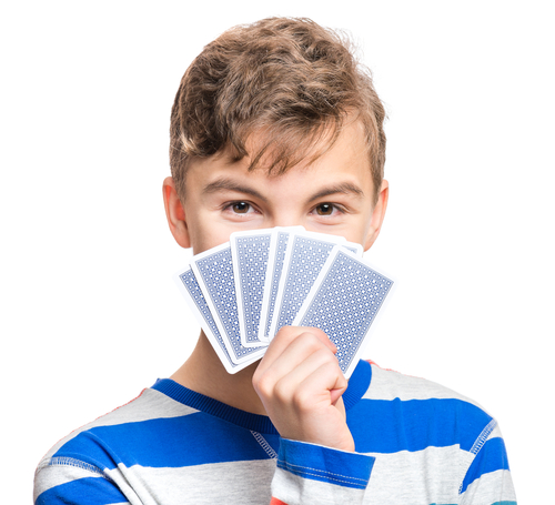 jeune garçon tenant un jeu de cartes