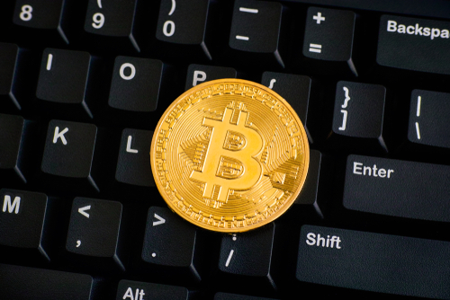 illustration d'une pièce dorée de bitcoin sur un clavier noir